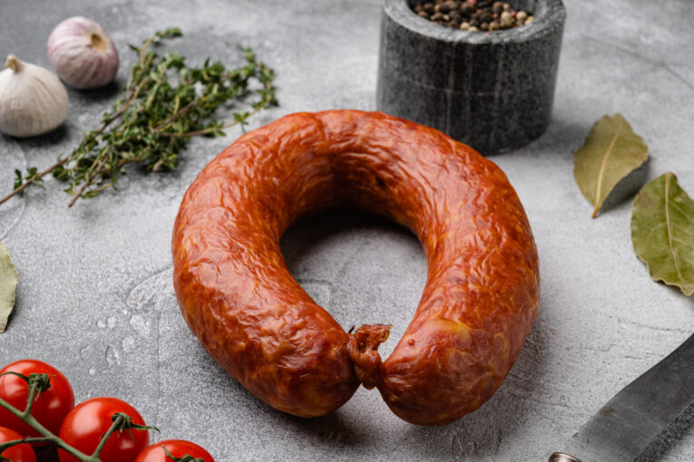 Pork dry cured meat sausage, on gray stone table background